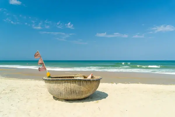 Traditional basket fishing boat resting on Hội An beach