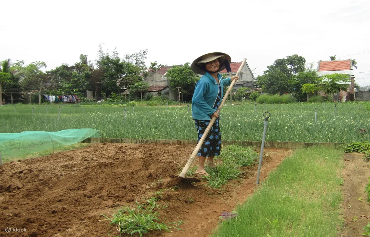 Ao Dai rider guiding a guest through mat weaving in Cam Kim Village