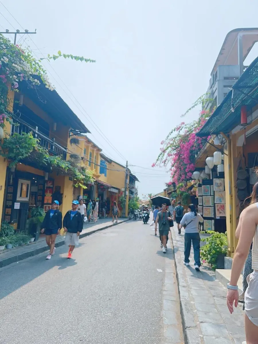Small group walking past yellow merchant houses